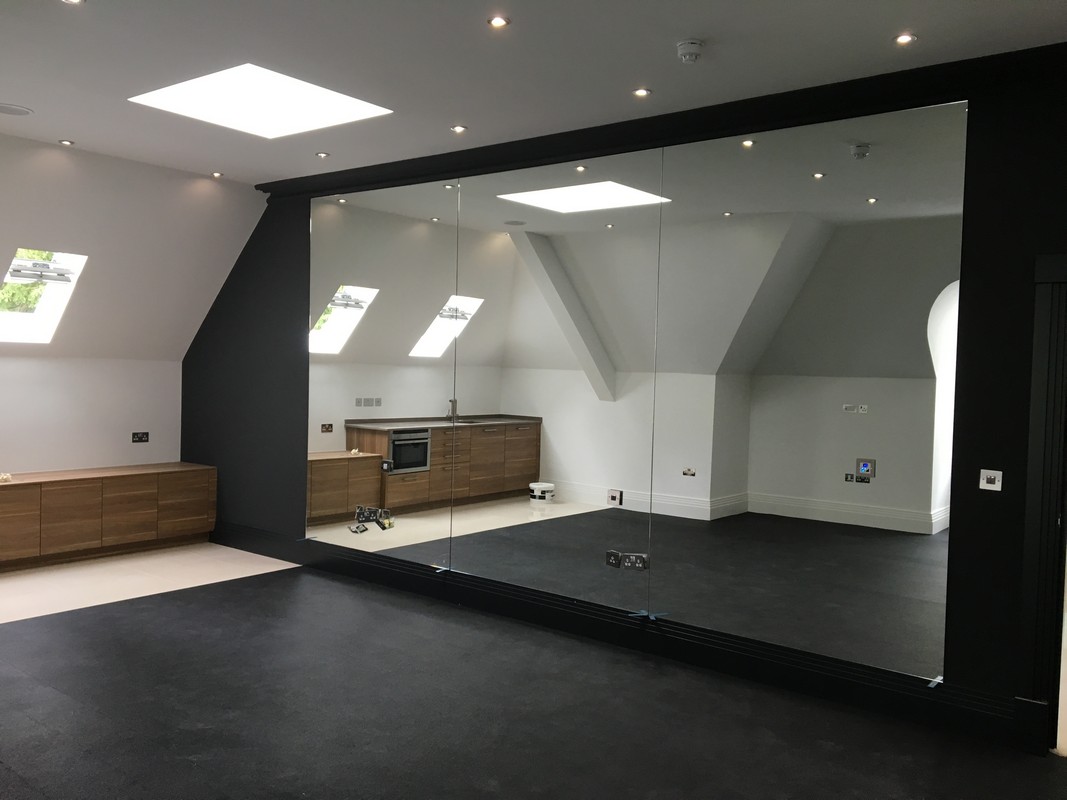 Frameless glass wall dividing loft conversion in Seven Sisters