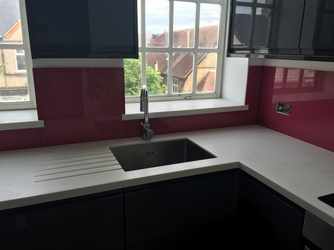 Deep plum coloured glass splashback in modern Seven Sisters kitchen